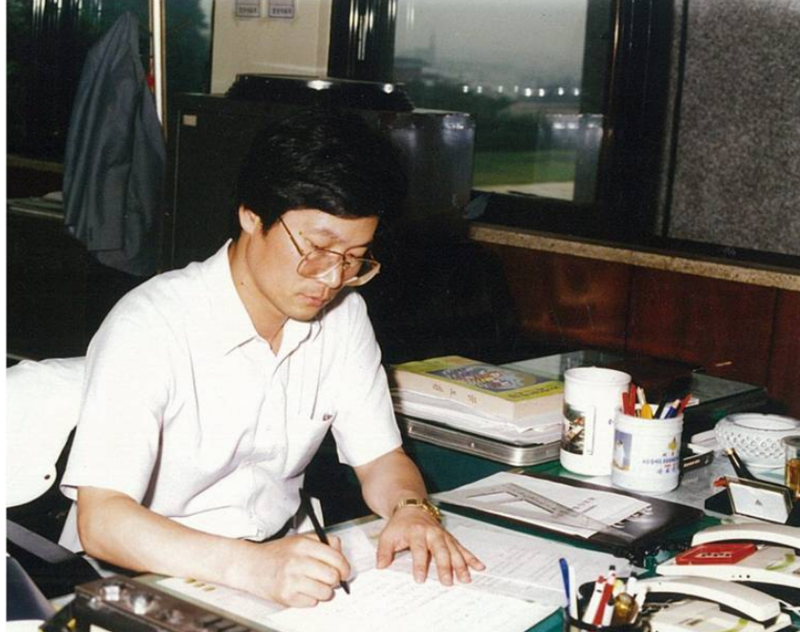 1988년 여름 7급 공무원으로 공보관실에서 보도자료를 정리하는 필자. 책상위에 PC가 없고 전화기 2대가 있는데 시외전화를 통제하기위해 번호판을 붉은 플라스틱 소재로 덮었다. 당시에는 대부분 펜으로 보도자료를 작성하여 기자실에 배포했다. 