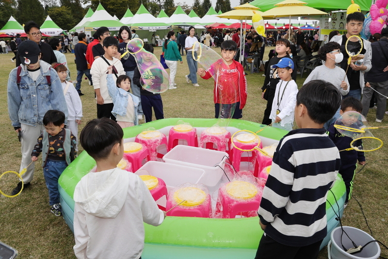 아이들이 축제현장에서 물방울 놀이를 즐기고 있다.