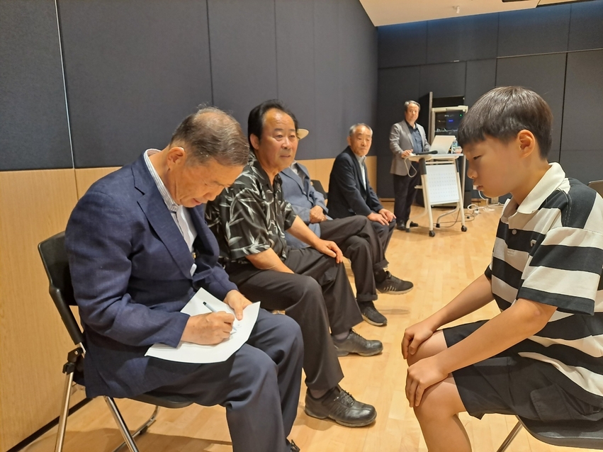 강의를 들으러 온 초등학생 형제에게 격려의 글과 서명을 쓰고 있는 김병조 선생 