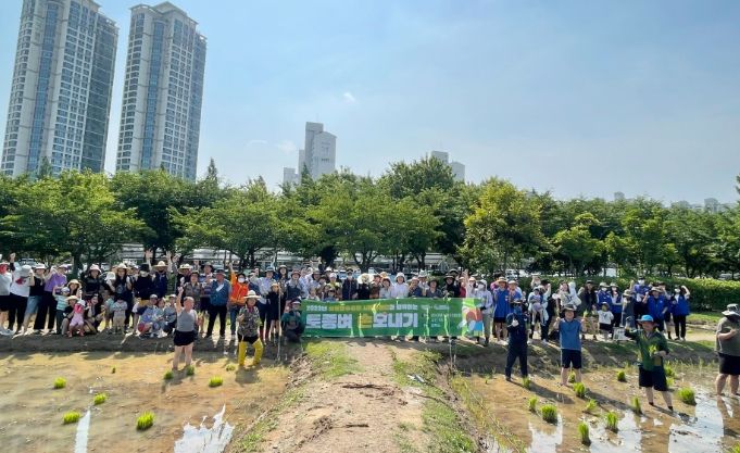 상동호수공원 ‘토종벼 손모내기’ 프로그램에 참여한 시민들이 활짝 웃으며 기념촬영을 하고 있다.