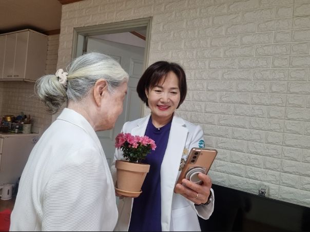 하남시에 거주하는 한 어르신이 하남시 방문간호사가 ‘마음속 새싹 가꾸기’ 프로그램 진행을 위해 전달한 꽃 화분을 바라보며 환하게 미소 짓고 있다.