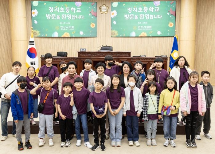안산시의회가 24일 정치초등학교 학생들을 대상으로 의회 견학 프로그램을 운영했다. 사진은 이날 본회의장에서 기념촬영에 임하고 있는 의원들과 정지초 학생들의 모습.