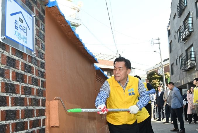 이재준 수원시장이 지난해 10월 수원형 저층주거지 집수리 지원사업 1호 기념식에서 페인트를 칠하고 있다.