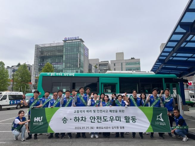 화성시 향남환승버스터미널에서 승하차 안전 도우미 활동에 참여하는 화성도시공사 임직원들이 단체 사진을 찍고 있다. (화성도시공사 제공)