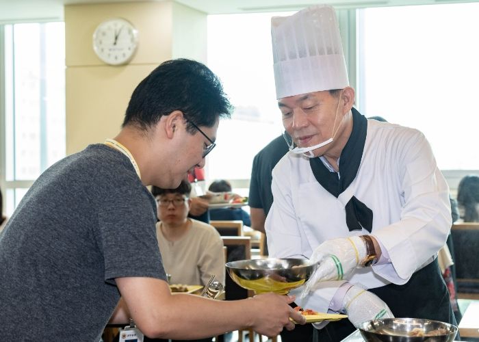 이재준 수원시장이 직원들에게 삼계탕을 배식하고 있다.