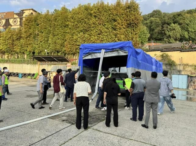 안양시가 지난 25일 버스공영차고지에서 실시한 자동식 질식소화포 시연 및 훈련에 참여자들이 소화수가 연결된 내부 모습을 살펴보고 있다