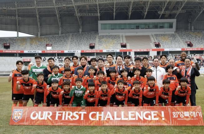 정명근 화성특례시장과 화성FC 선수, 에스코트 키즈들이 K리그2 홈경기 개막전에서 단체사진을 찍고 있다